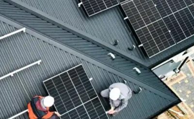 Equipe realizando instalação de sistema fotovoltaico em telhado residencial.